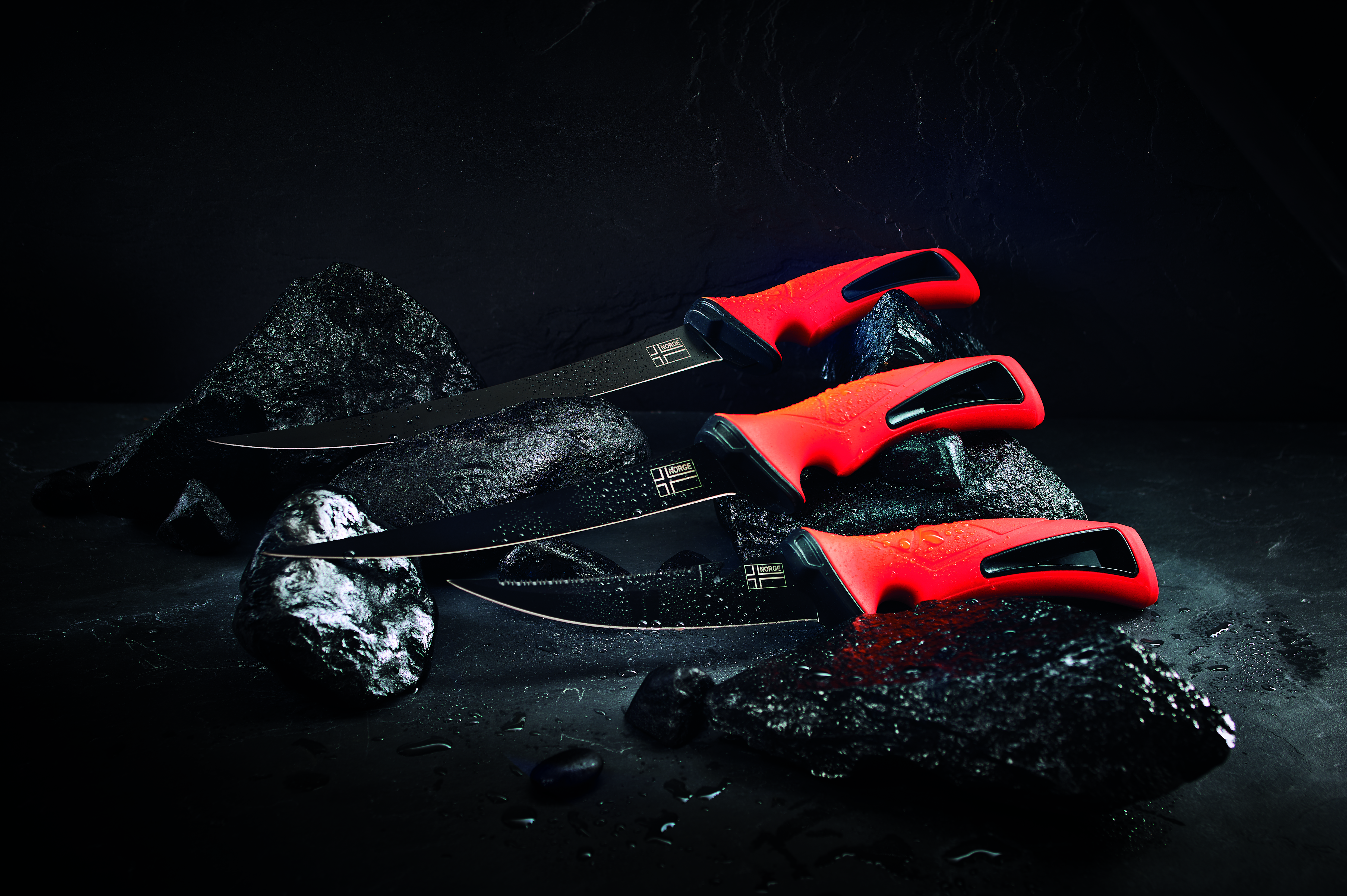 Drei Filetiermesser mit orangefarbenen Griffen zum Zubereiten von Fisch zum Grillen oder Kochen. – Fishing Adventure GmbH