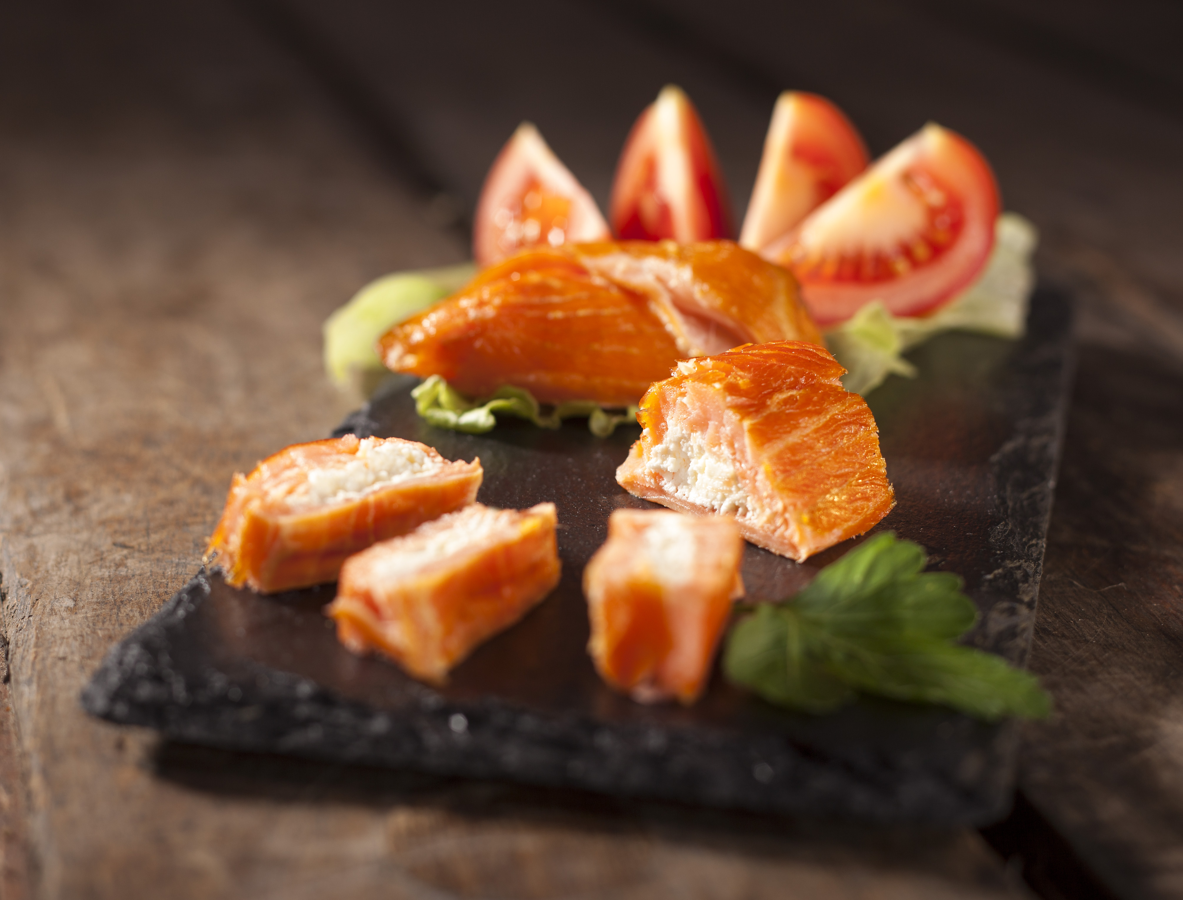 Geräucherter Lachs mit Frischkäse und Tomaten, serviert auf einer schwarzen Schiefertafel als Vorspeise oder leichtes Mittagessen. – Fishing Adventure GmbH
